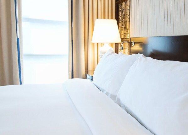Plush bedding and soft lighting, creating a serene retreat for restful nights and refreshed mornings.