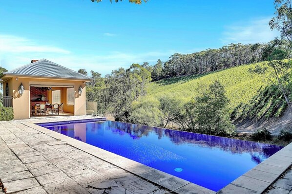 For those seeking a tranquil retreat, the infinity-edge pool offers breathtaking views of the neighboring vineyard from its elevated stone terrace, blending the waterline seamlessly with the natural landscape.