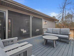 Great back deck has stairs with railings that lead to picnic area and grill. 
