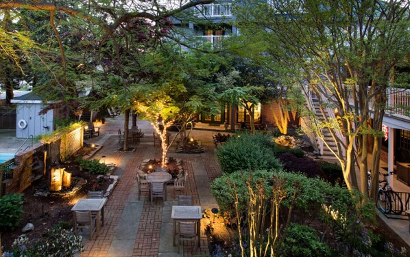 As the sun sets, the garden comes alive with soft lighting and tranquil pathways for a relaxing stroll.