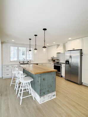 Kitchen includes coffee maker, toaster oven, beverage fridge and microwave.