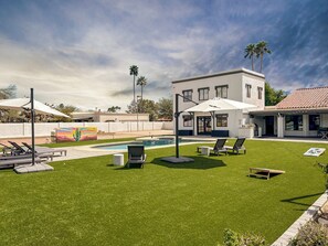 Spacious turf yard, cactus mural, and pool—perfect for fun under the AZ sun