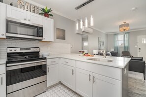 The fully equipped kitchen features culinary essentials, stainless steel appliances, and a kitchen island with bar seating for 4 guests.