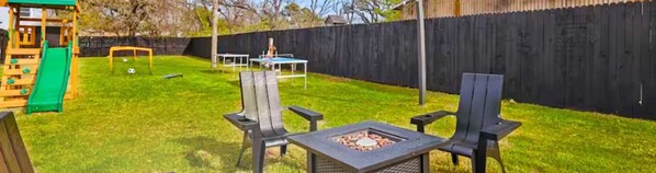 “Relaxing Backyard with Fire Pit & Games”
Unwind around the fire pit, let the kids explore the playset, or enjoy a friendly game of ping pong — all under charming string lights in this fenced shared yard.