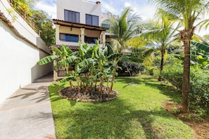 The condo has great privacy with a large greenspace in front, flanked by palm trees and banana plants.