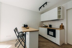 Minimalistisches Küchendesign mit gemütlicher Frühstücksbar. Starte den Tag mit einem frischen Kaffee oder bereite ein entspanntes Dinner in der voll ausgestatteten Küche zu. Perfekt für Kurz- & Langzeitaufenthalte!