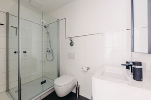Modernes Badezimmer mit begehbarer Dusche. Klare Linien, stilvolle Armaturen und ein durchdachtes Design sorgen für höchsten Komfort. Dein perfekter Ort für eine erfrischende Auszeit!