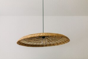 Die handgeflochtene Rattanlampe setzt ein stilvolles Statement und sorgt für ein warmes, sanftes Licht. Ihr natürliches Design verleiht dem Raum eine gemütliche Atmosphäre und verbindet moderne Eleganz mit rustikalem Charme.