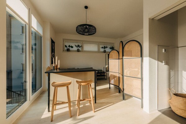 Ein lichtdurchflutetes Loft mit stilvoller Einrichtung und natürlichem Flair. Die Kombination aus Holz, Rattan und sanften Farben schafft eine warme, einladende Atmosphäre – perfekt für entspanntes Wohnen und kreative Momente.