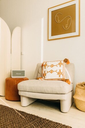 Ein Platz zum Verweilen – dieser gemütliche Sessel mit Boho-Kissen lädt zum Entspannen ein. Der warme Mix aus Naturtönen, weichen Stoffen und stilvollen Details schafft eine harmonische Atmosphäre. Perfekt für eine Pause mit guter Musik.