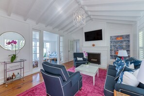 Large Great Room with vaulted ceilings open to Florida Room and dining with queen Sleeper Sofa, Smart TV, fireplace & chic decor.