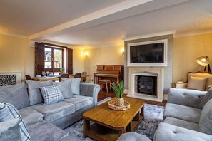 Relax in style, cosy sofas, a Smart TV, and a piano with stunning views of the countryside. 