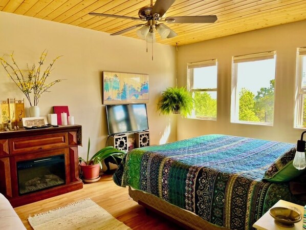 Bedroom with electric fireplace heater and tv monitor.