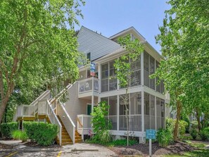 Beautifully designed condo with a screened-in porch, nestled among lush greenery for a peaceful retreat.