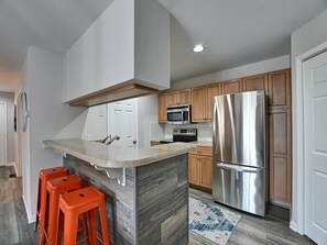 A modern kitchen with bar seating and an open layout, ideal for entertaining guests.