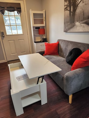 The coffee table top rises to be a workstation or place for drawing or eating.