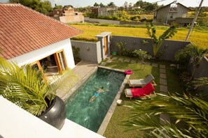 From the second level, enjoy a perfect poolside escape: swim or relax.