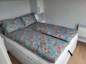 Bed. Extra mattress and baby crib are stored under the bed with extra bedsheets
