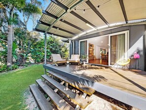 The front entrance features a covered patio with seating.