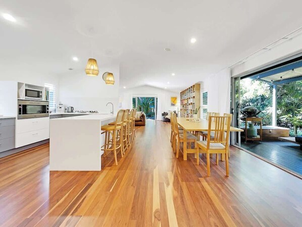 The open plan kitchen and dining area seamlessly flows to the side deck.