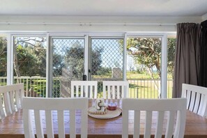 Gather around the indoor dining table for shared meals, casual snacks, or a morning coffee, all while enjoying glimpses of the ocean beyond.