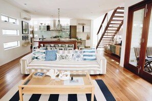 The open-plan living area is Hamptons-inspired, with a calm coastal, colour pallet and comfortable seating.