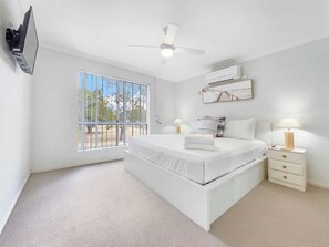 Drift off in the spacious first bedroom, furnished with a queen-sized bed and coastal-inspired décor.