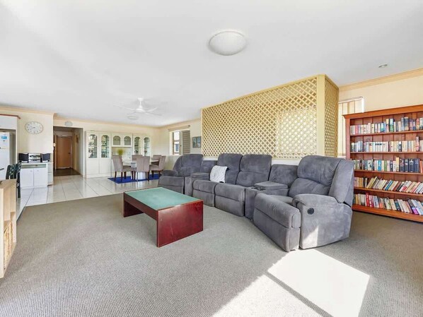 Unwind in our spacious living area, featuring plush seating and ample natural light—perfect for family gatherings or a cosy movie night