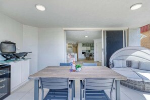 The balcony offers an alfresco dining area with a BBQ grill and mini fridge.