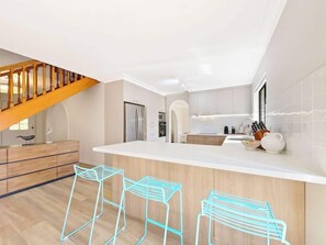 A sleek breakfast bar provides seating for three.