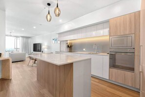 Cook, dine, and connect in a sleek, open-plan kitchen complete with modern appliances and all the essentials—perfect for shared meals or morning coffees before the beach.