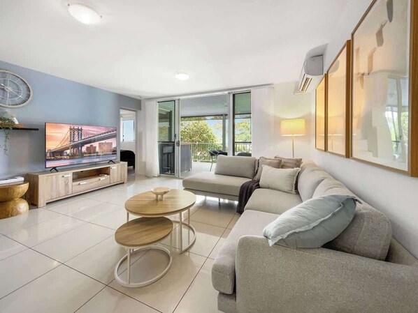 Relax in a light-filled living space with plush seating, sea breezes, and direct access to the spacious balcony – perfect for unwinding after a day at the beach.