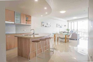 Cook with ease in the modern kitchen, complete with a breakfast bar, stainless steel appliances, and sleek stone benchtops.