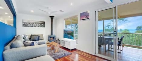 Relax in the main lounge, featuring comfortable seating, a flat-screen TV, and large windows framing the mountain views.
