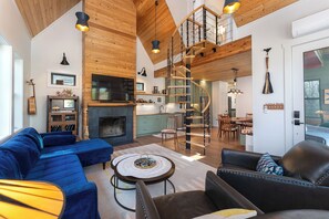 Living room with 60" TV, DVD player, and wood-burning fireplace