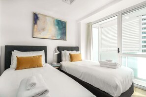 Rest easy and breathe freely in our cozy retreat, featuring premium mattresses and pillows encased in top-quality anti-mite protectors for your ultimate comfort and health. 

Bedroom opens up to a balcony. 