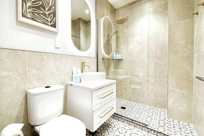 Step into a world of indulgence in this captivating  bathroom. Adorned with heritage mosaic tiles, enjoy this timeliness design. Delight in the backlit anti-fog mirror, spa showerhead, and heated towel rack for a truly luxurious experience. 