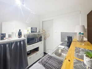 Petite cuisine lumineuse et moderne, cette pièce est équipée d'appareils pratiques comme un four et une cafetière. Le coin est idéal pour préparer de délicieux repas dans une ambiance conviviale.