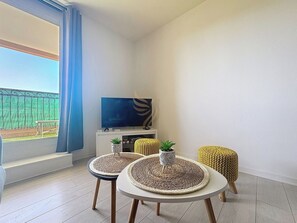 Ce salon minimaliste et lumineux permet une belle ambiance relaxante. Profitez de la lumière naturelle pour lire un bon livre ou détendez-vous en regardant la télé. L'espace extérieur promet des déjeuner ensoleillés.