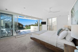 The master bedroom with a king bed overlooks the private balcony and beach.