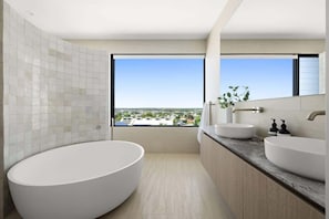 Indulge in a spa-like bathroom with a round soaking tub and dual vanities.