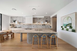 Cook and connect in the high end kitchen with stone textures and top appliances.
