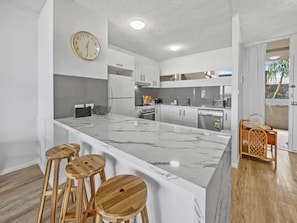 The stunning kitchen offers premium appliances and a central island with additional seating.