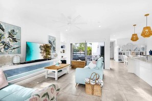 Relax with a movie in the spacious main living area, bathed in natural light and coastal tones.