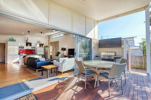 Large sliding doors extend from the open-plan living area to the back deck.