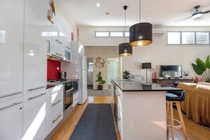 Cook up a storm in the stylish kitchen, fully equipped with modern appliances, a large fridge, and plenty of space for family feasts or casual snacks.