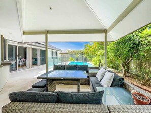 Dine outdoors or unwind with evening drinks in the covered alfresco space, overlooking the private pool and garden.

