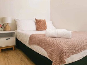 Bedroom Two offers a queen bed, ceiling fan, and relaxed coastal styling.