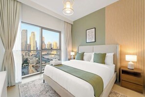 Bedroom #1 with a king-size bed and wide views of Downtown and the Burj Khalifa. Comes with its own en-suite bathroom featuring a double vanity and walk-in shower. Soft light, clean lines, and total comfort !