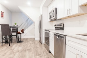 The seamless open kitchen features top-of-the-line appliances, a spacious island with comfy seating, and a bright dining area - perfect for friends and family. #ChefMode